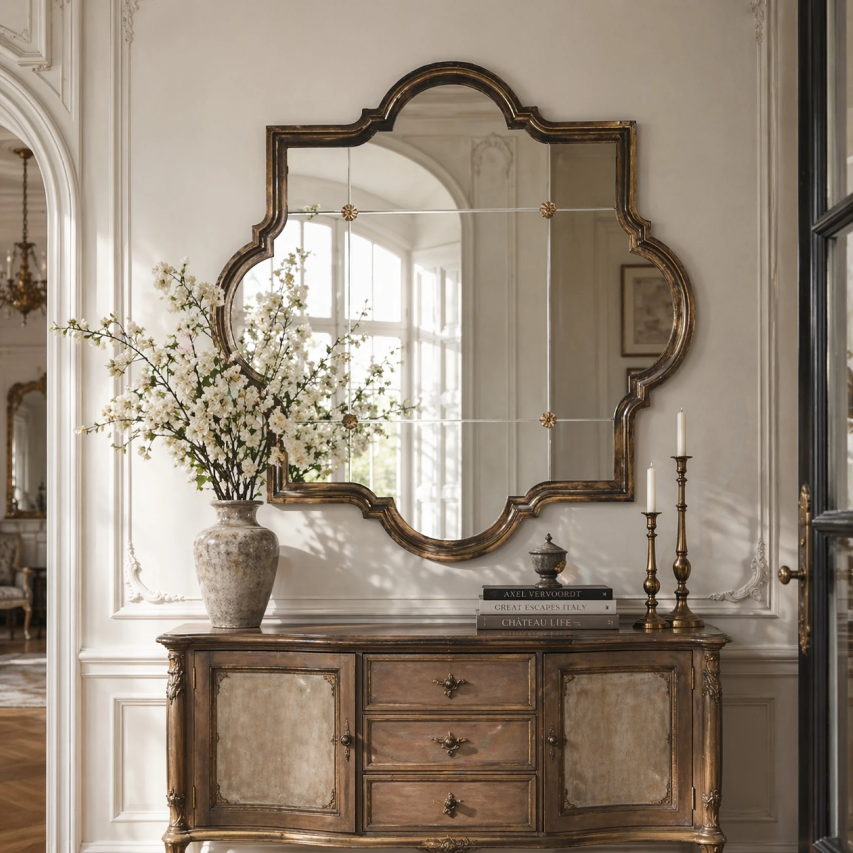 Zentique collection inspiration with a carved console, shaped mirror and floral arrangement